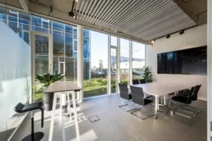 Moderne vergaderruimte aan de Fred. Roeskestraat met grote ramen, strakke meubels en een flatscreen aan de muur.